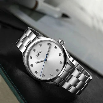 RADO watch with a steel bracelet worn on a man's wrist in a navy blue suit, perfect professional look. Nayvo Noir style.